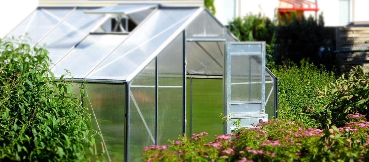 A greenhouse within a garden setting.